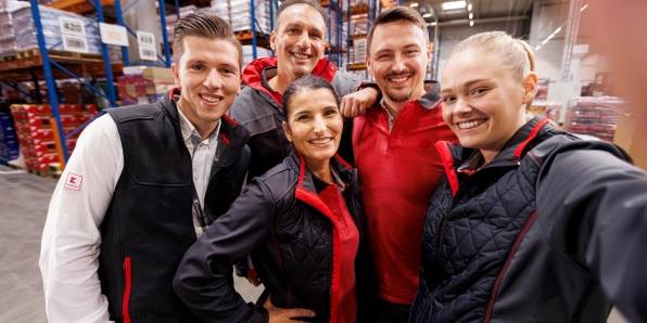 Gruppen-Selfie: Fünf Logistikmitarbeiter von Kaufland posieren vor der Handykamera.