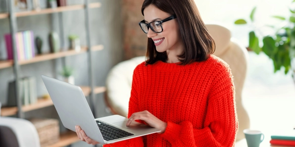 Frau arbeitet mobil von einem Café aus an ihrem Laptop.