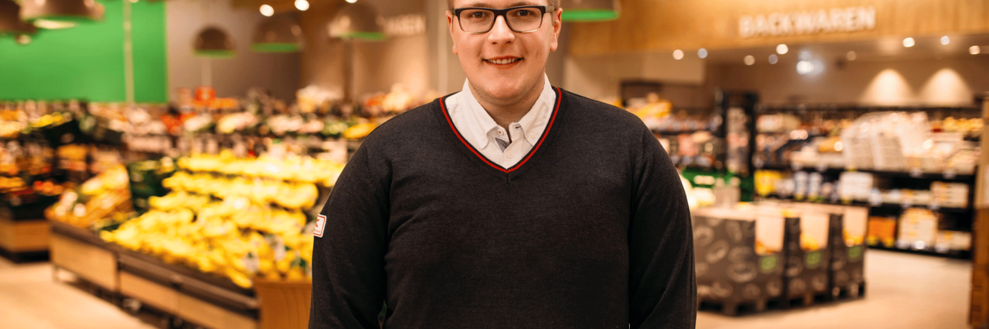 Abiprogramm Teilnehmer und Filialleiter bei Kaufland steht vor dem Obst- und Gemüsebereich.