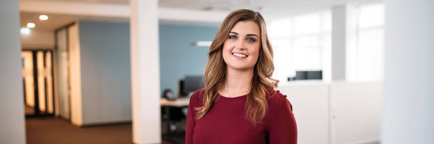 Kaufland-Mitarbeiterin steht auf dem Büroflur.