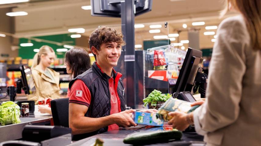 An der Kasse in einer Kaufland-Filiale: Junger Mitarbeiter kassiert den Einkauf einer Kundin.