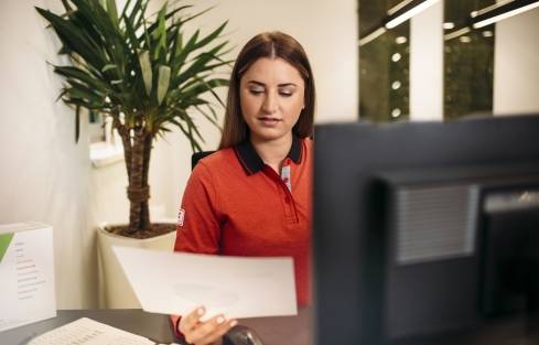 Auszubildende im Verkauf erledigt Back-Office-Aufgaben am Computer.