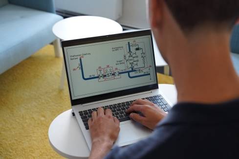 Dualer Student bei Kaufland arbeitet am Laptop und betrachtet Lerninhalte aus dem Studiengang Bauingenieurwesen.