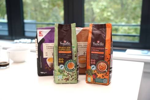 Kaffeeverpackungen der Eigenmarke K-Classic und K-Favourites stehen auf einem Tisch.