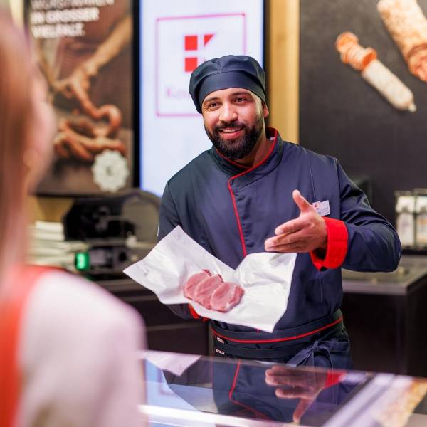 An der Bedientheke einer Kaufland-Filiale: Mitarbeiter in der Fleisch- und Wurstabteilung präsentiert der Kundin 4 Scheiben des gewünschten Fleisches.