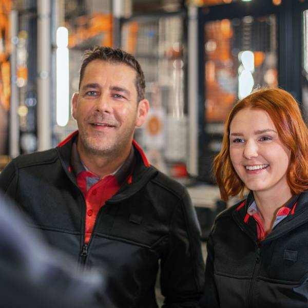 Zwei Logistik-Mitarbeiter von Kaufland unterhalten sich mit einem Kollegen.