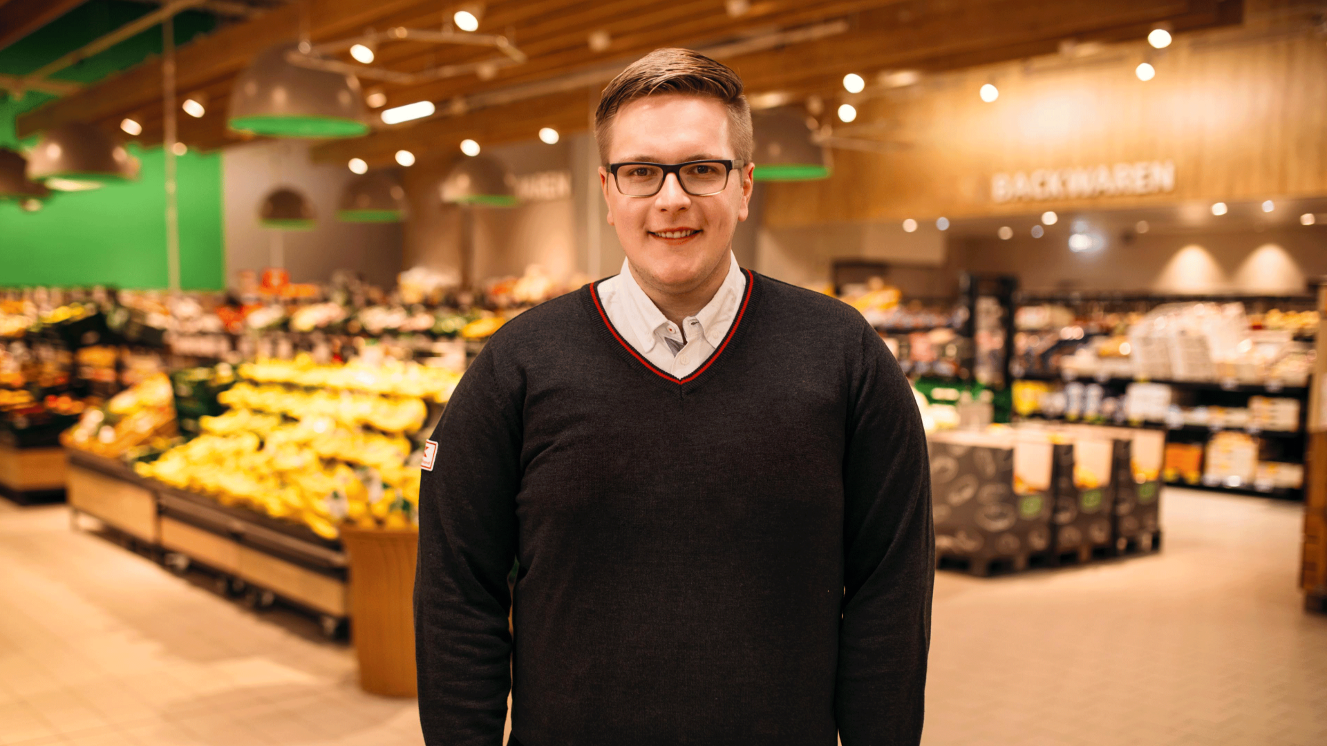 Abiprogramm Teilnehmer und Filialleiter bei Kaufland steht vor dem Obst- und Gemüsebereich.
